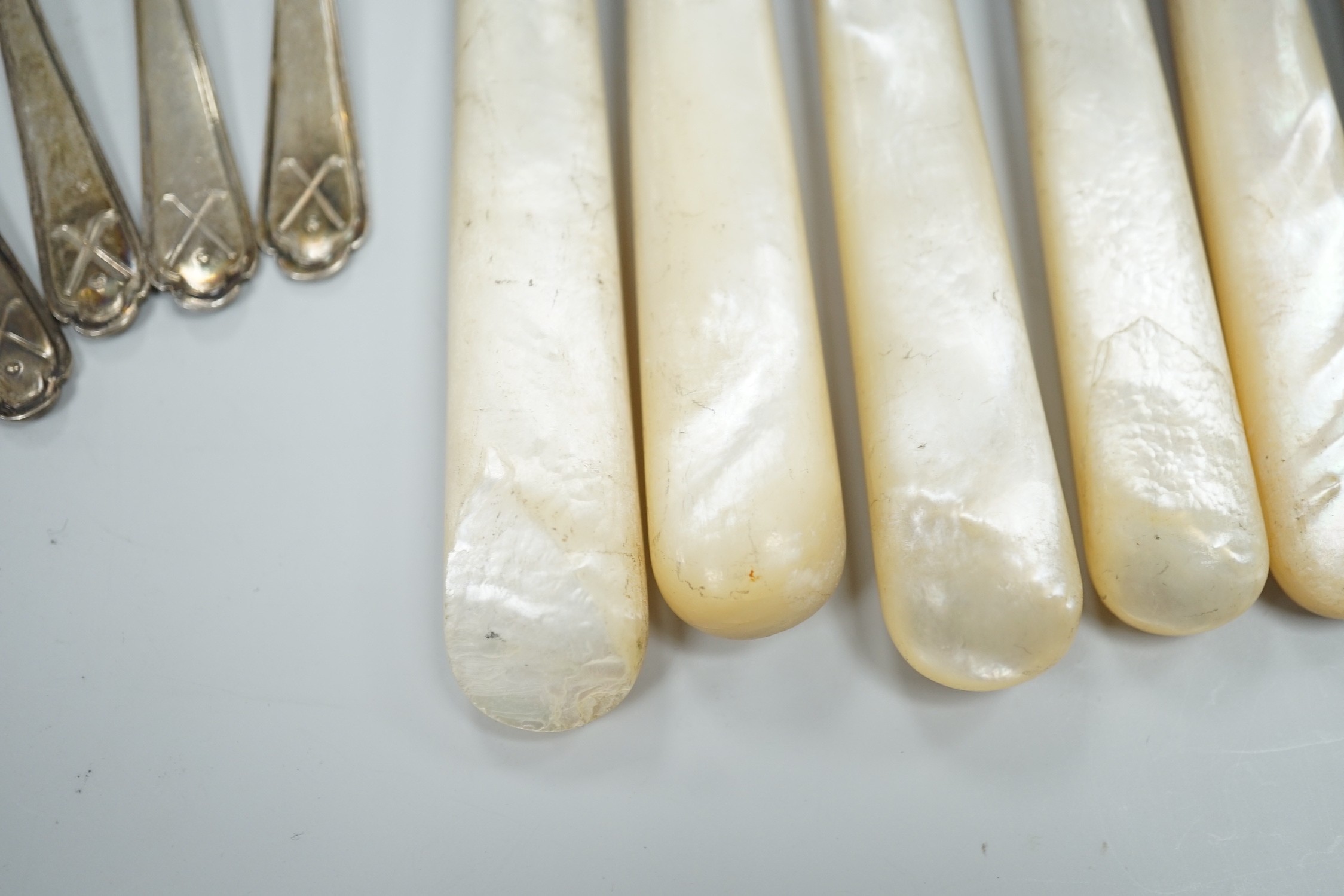 A set of six George V golfing related teaspoons, Walker & Hall, Sheffield, 1933 and seven mother of pearl handled silver dessert eaters.